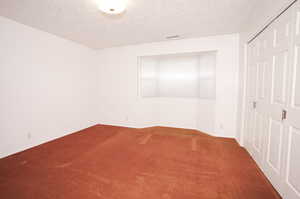 Interior space with a textured ceiling and carpet floors