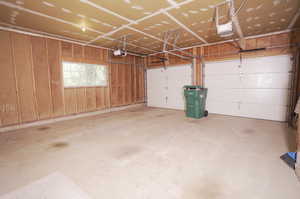 Garage with a garage door opener and wood walls