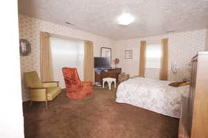 Bedroom with a textured ceiling and carpet flooring