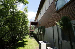 View of yard with central AC unit and a balcony