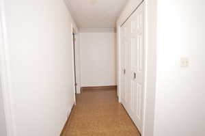 Hallway featuring a textured ceiling and tile floors