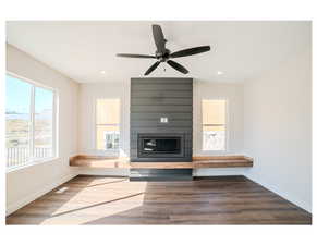 Unfurnished living room featuring ceiling fan and hardwood / wood-style floors