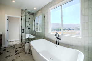 Bathroom with shower with separate bathtub, a mountain view, and vanity