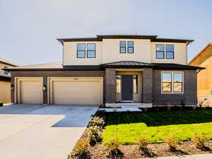 View of front facade featuring a front yard and a garage