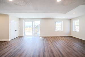 Unfurnished room featuring a textured ceiling and dark wood-type flooring