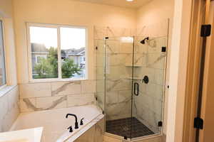 Bathroom featuring plenty of natural light and shower with separate bathtub