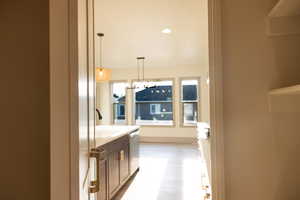 Kitchen featuring light hardwood / wood-style flooring, dishwasher, sink, and hanging light fixtures