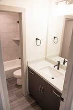 Full bathroom with vanity, toilet, and tiled shower / bath