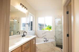 Bathroom featuring vanity and separate shower and tub