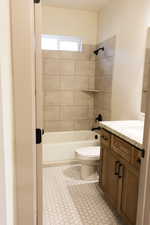 Full bathroom featuring vanity, toilet, tiled shower / bath combo, and tile patterned floors