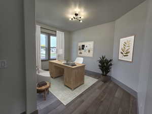 Office area featuring an inviting chandelier, a textured ceiling, and dark wood-type flooring