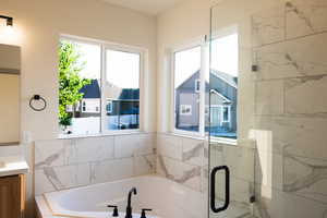 Bathroom featuring vanity and separate shower and tub