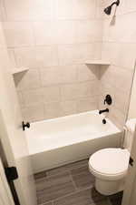 Bathroom featuring toilet and tiled shower / bath combo