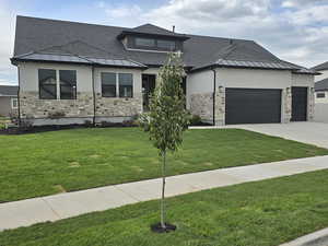 Prairie-style house with a garage and a front lawn