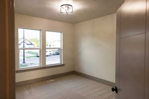 Empty room with a textured ceiling and carpet