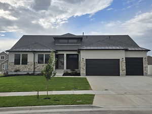 Prairie-style house featuring a front lawn and a garage