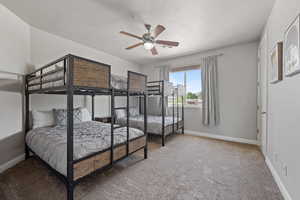 Carpeted bedroom with ceiling fan