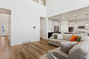 View of living room showing kitchen and entry into the home