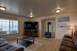 Living room featuring a textured ceiling, a heating stove, and hardwood / wood-style floors