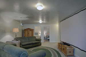 Living room with carpet flooring and a textured ceiling