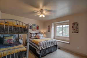 Carpeted bedroom with ceiling fan