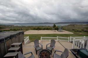 View of terrace, oversized hot tub, with a playground and a water view