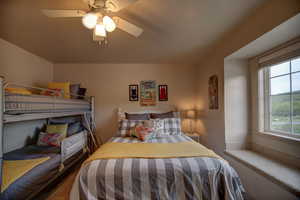 Carpeted bedroom featuring ceiling fan