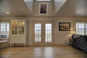 Doorway featuring wood-type flooring, plenty of natural light, and french doors