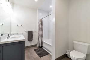 Full bathroom with tile flooring, shower / bath combo, toilet, and vanity