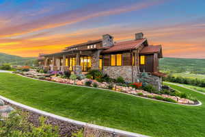 View of front of home with a yard and central air condition unit