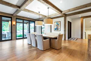 Dining space with coffered ceiling, beam ceiling, and hardwood / wood-style flooring