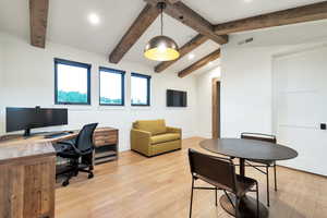 Office featuring light hardwood / wood-style floors and vaulted ceiling with beams