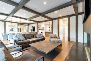 Living room featuring coffered ceiling, beam ceiling, and hardwood / wood-style flooring