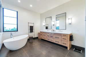 Bathroom featuring a bath, tile flooring, and double vanity