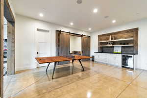 Kitchen with a barn door, white cabinets, and wine cooler