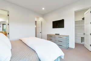 Carpeted bedroom with a closet and a spacious closet