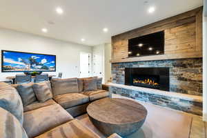 Living room with wood walls and a stone fireplace