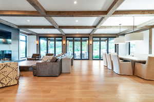 Living room with beam ceiling, coffered ceiling, and light hardwood / wood-style floors