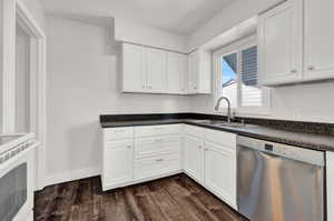 Kitchen featuring dark hardwood / wood-style floors, sink, dishwasher, and white cabinetry