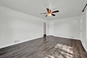 Unfurnished room featuring dark hardwood / wood-style floors and ceiling fan