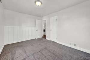 Spare room featuring dark colored carpet