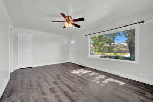 Unfurnished room with dark wood-type flooring and ceiling fan