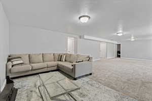 Carpeted living room featuring a textured ceiling