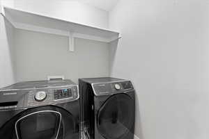 Clothes washing area featuring independent washer and dryer and washer hookup