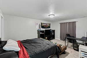 Carpeted bedroom featuring a textured ceiling