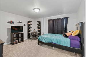 Bedroom featuring a textured ceiling and carpet floors