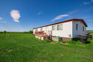 Back of property with a deck and a yard