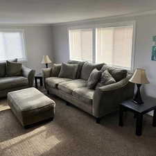 Carpeted living room featuring a wealth of natural light and ornamental molding