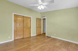 Unfurnished bedroom with ceiling fan, a closet, and light wood-type flooring