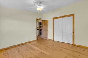 Unfurnished bedroom featuring a closet, light wood-type flooring, and ceiling fan